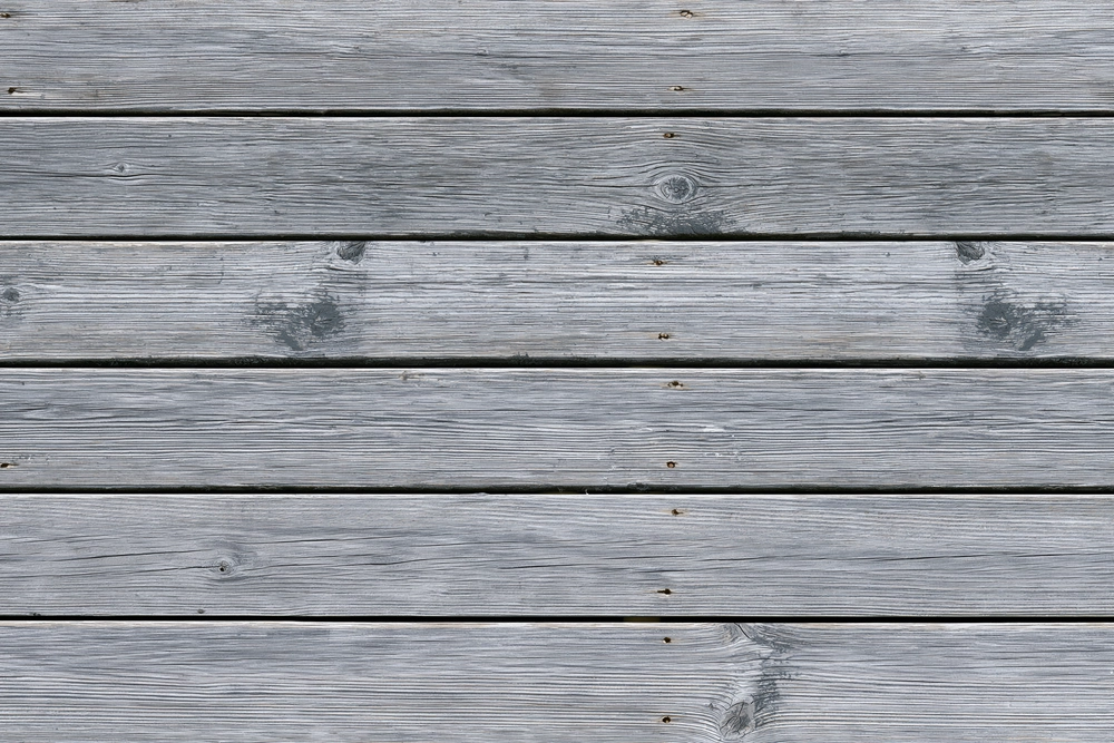 Illustration of weathered gray deck boards with darker grain and joints