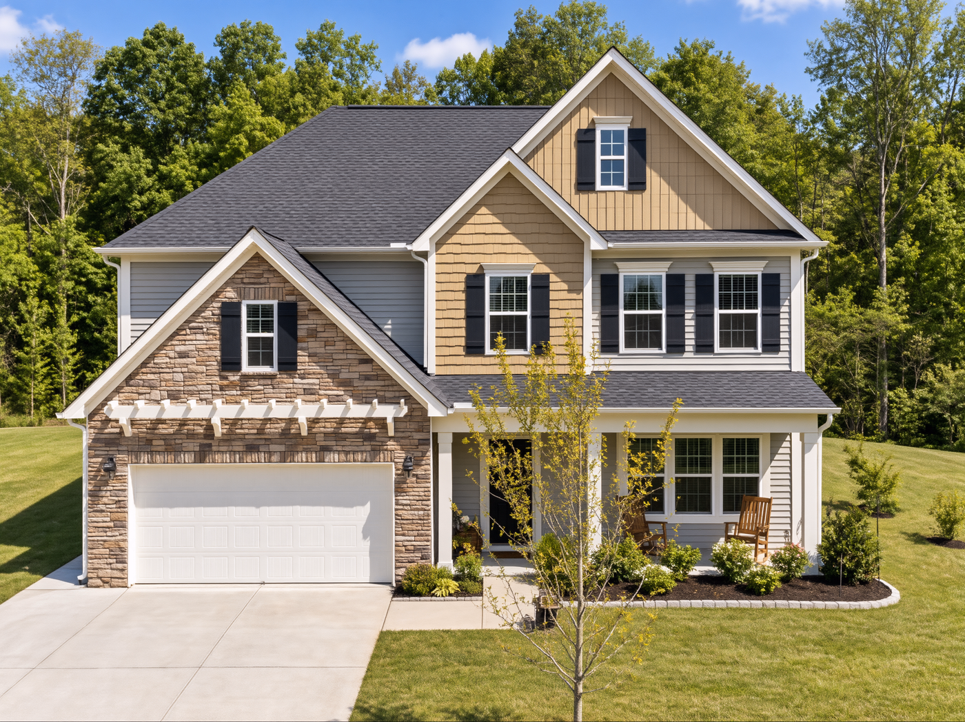 Craftsman house with stone, gray and tan siding, nested gables, garage and driveway